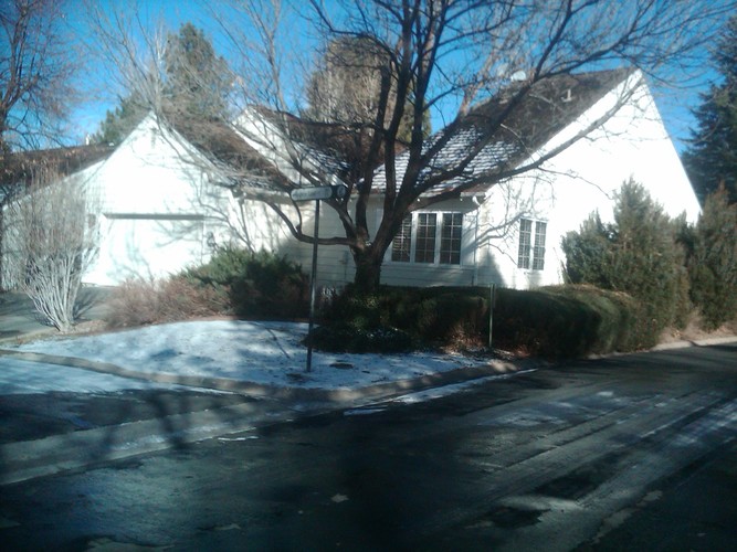 A white house with a tree in front of it.