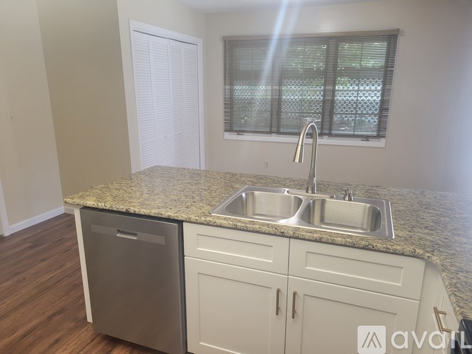A kitchen with a granite countertop and stainless steel appliances.