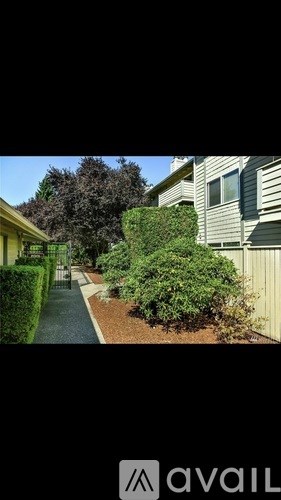 A residential area with a house, a tree, and a hedge.