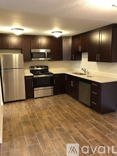 A kitchen with wooden cabinets and a tile floor.