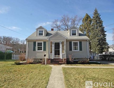 A two-story house with a front porch and a small front yard.