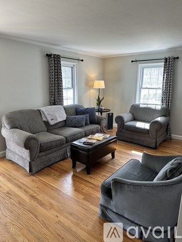 A living room with grey couches and a wooden floor.