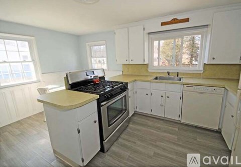 A kitchen with white cabinets and a black stove top oven.