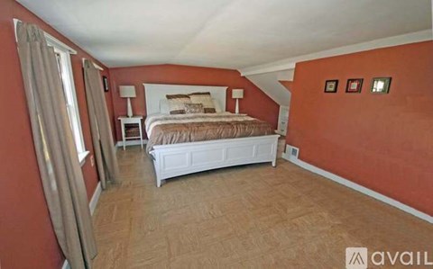 A bedroom with a bed, nightstand, and chair.