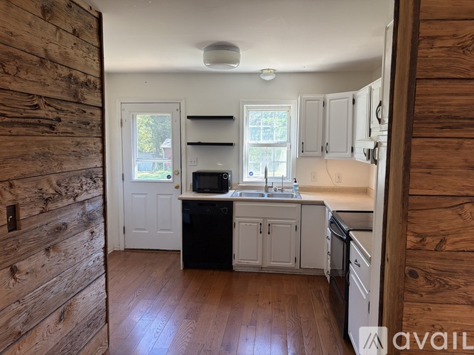 A kitchen with wooden walls and white appliances.