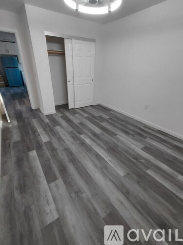 A room with a wooden floor and white walls.