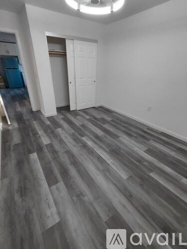 A room with a wooden floor and white walls.