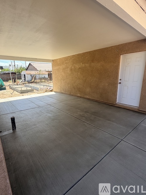 A room with a white door and a concrete floor.