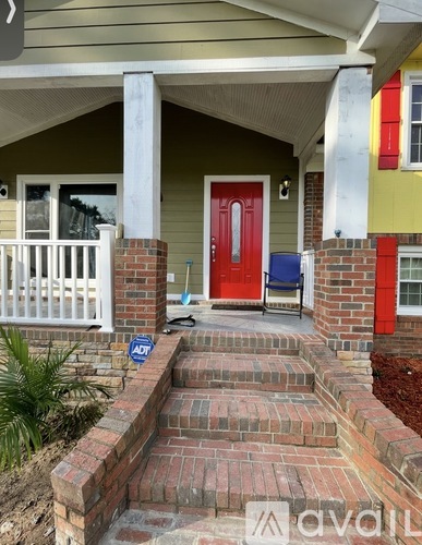 A house with a red door and a white porch.