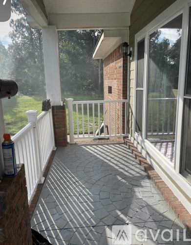 A patio with a white railing and a brick pillar.
