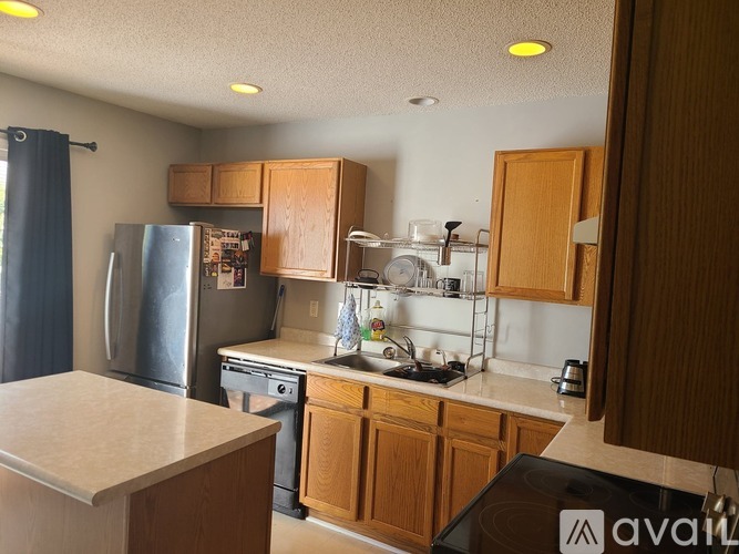 A kitchen with wooden cabinets and a refrigerator.