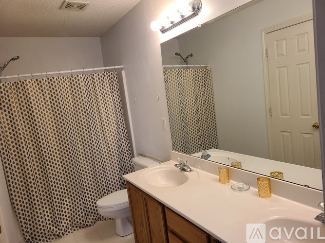 A bathroom with a toilet, sink, and shower curtain.