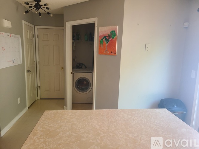 A bedroom with a washing machine in the closet.