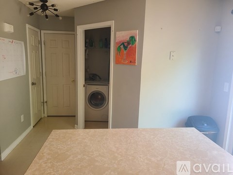 A bedroom with a washing machine in the closet.