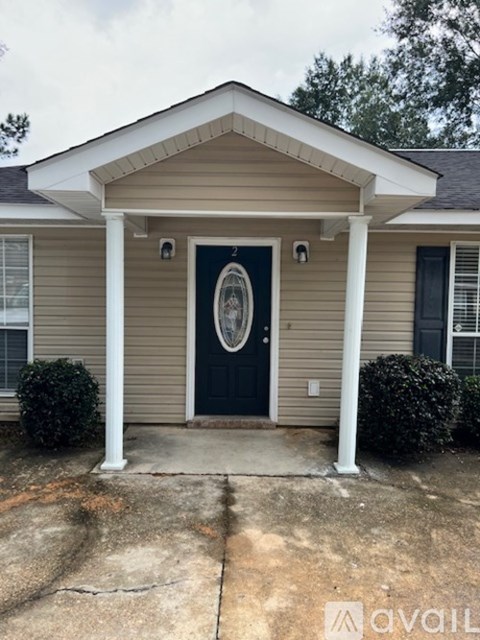 A house with a dark blue door and white columns.