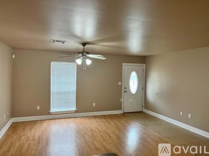 A room with a ceiling fan and a door with a window above it.