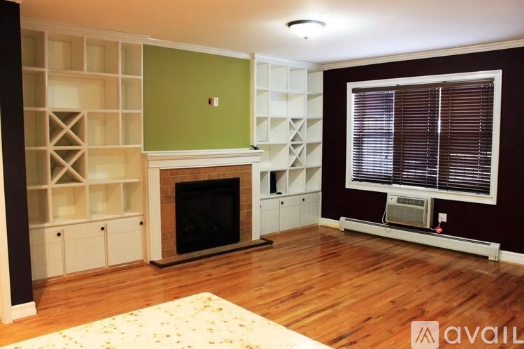 A living room with a fireplace and built in shelves.
