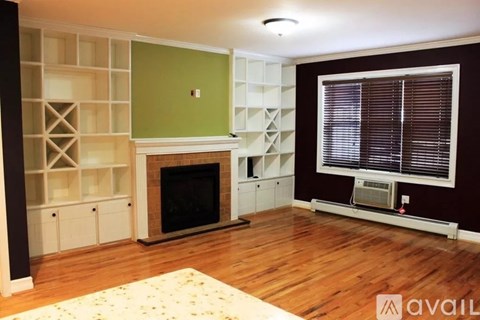A living room with a fireplace and built in shelves.