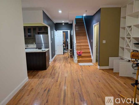 A wooden floor leads up to a staircase in a house.