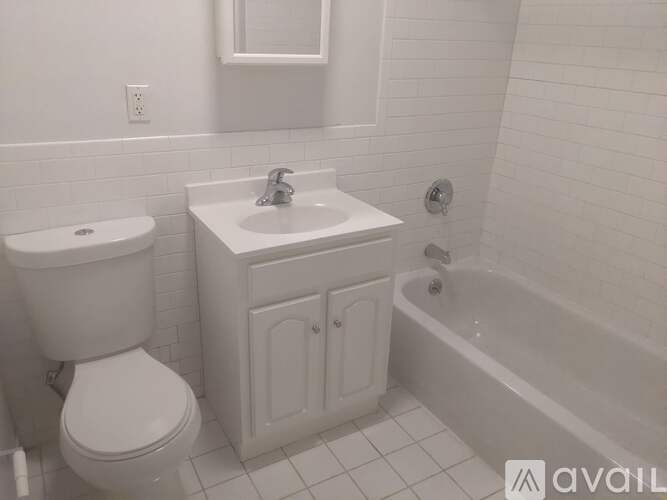 A white bathroom with a toilet, sink, and bathtub.