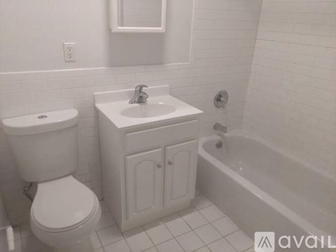 A white bathroom with a toilet, sink, and bathtub.