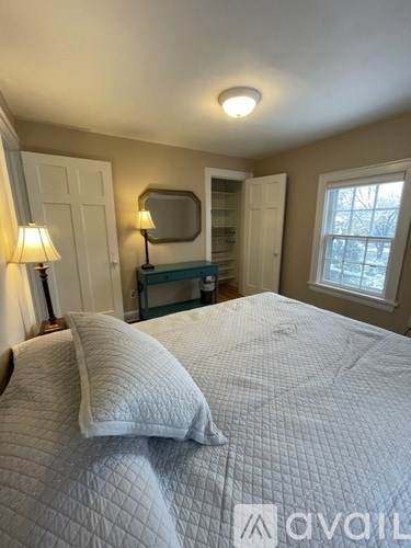 A bedroom with a bed, a dresser, and a window.