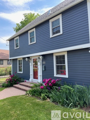 A blue house with a red door and windows.