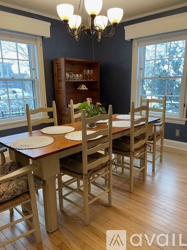 A dining room with a wooden table and chairs.