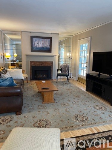 A living room with a fireplace and a painting above it.