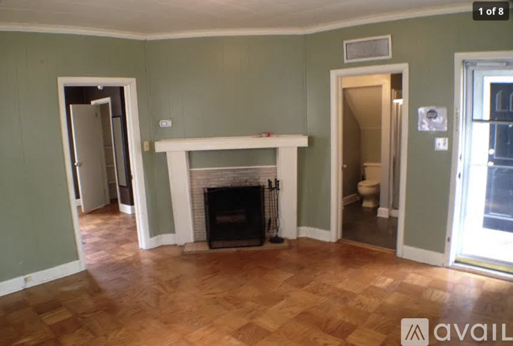 A room with a fireplace and wood flooring.