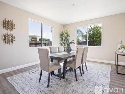 A dining room with a table and chairs.