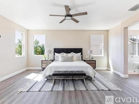 A bedroom with a large bed and a ceiling fan.