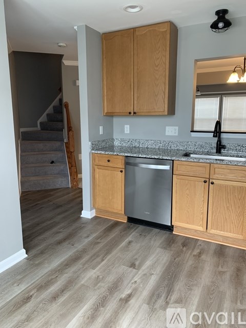 A kitchen with wooden cabinets and a granite countertop.