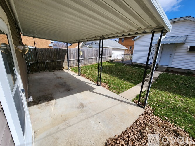 A patio with a white awning and a black fence.