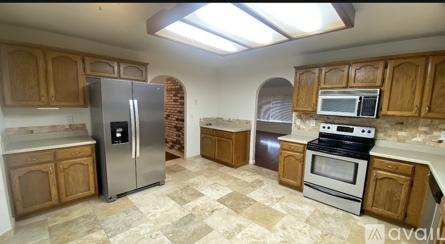 A kitchen with wooden cabinets and a tiled floor.