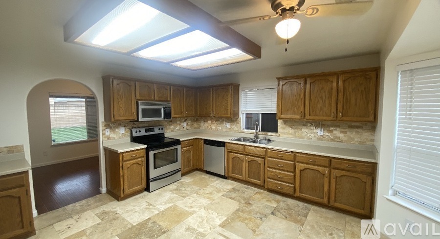 A kitchen with wooden cabinets and a tile floor.
