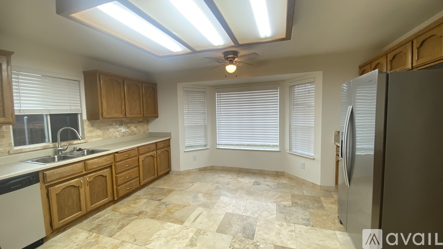A kitchen with wooden cabinets and a tiled floor.