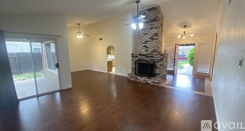 A living room with a stone fireplace and hardwood floors.