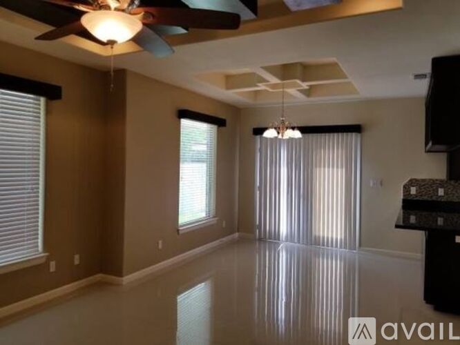 A spacious living room with a ceiling fan and a flat screen TV.
