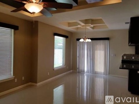 A spacious living room with a ceiling fan and a flat screen TV.