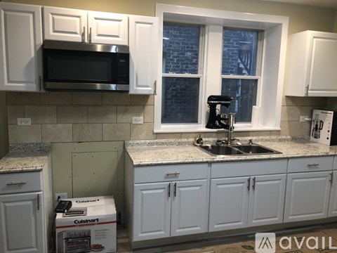 A kitchen with white cabinets and a microwave above the stove.