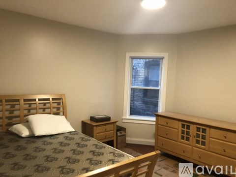 A bedroom with a bed, nightstand, and dresser.