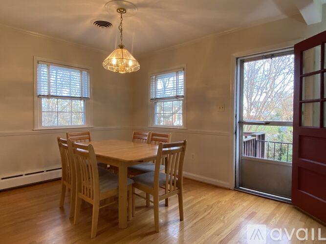 A dining room with a wooden table and chairs.
