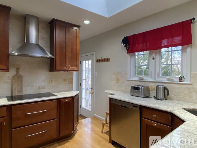 A kitchen with wooden cabinets and a marble countertop.