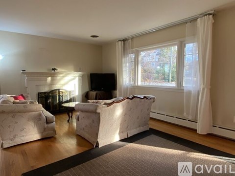A living room with white furniture and a flat screen TV.
