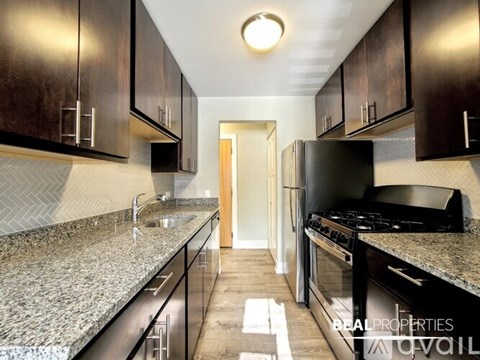 A modern kitchen with granite countertops and stainless steel appliances.