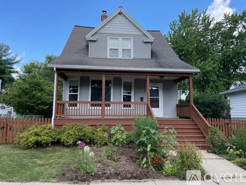 A house with a grey roof and a brown fence.