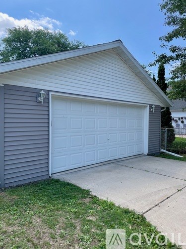 A house with a garage door and a driveway.