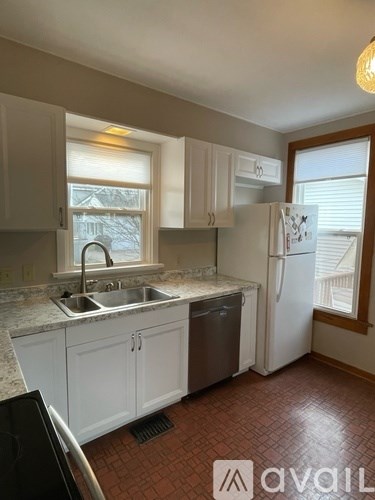 A kitchen with white cabinets and a black dishwasher.