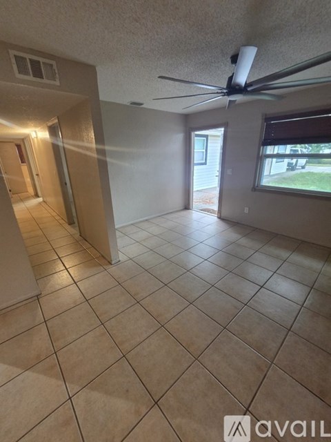 A room with a ceiling fan and tile flooring.